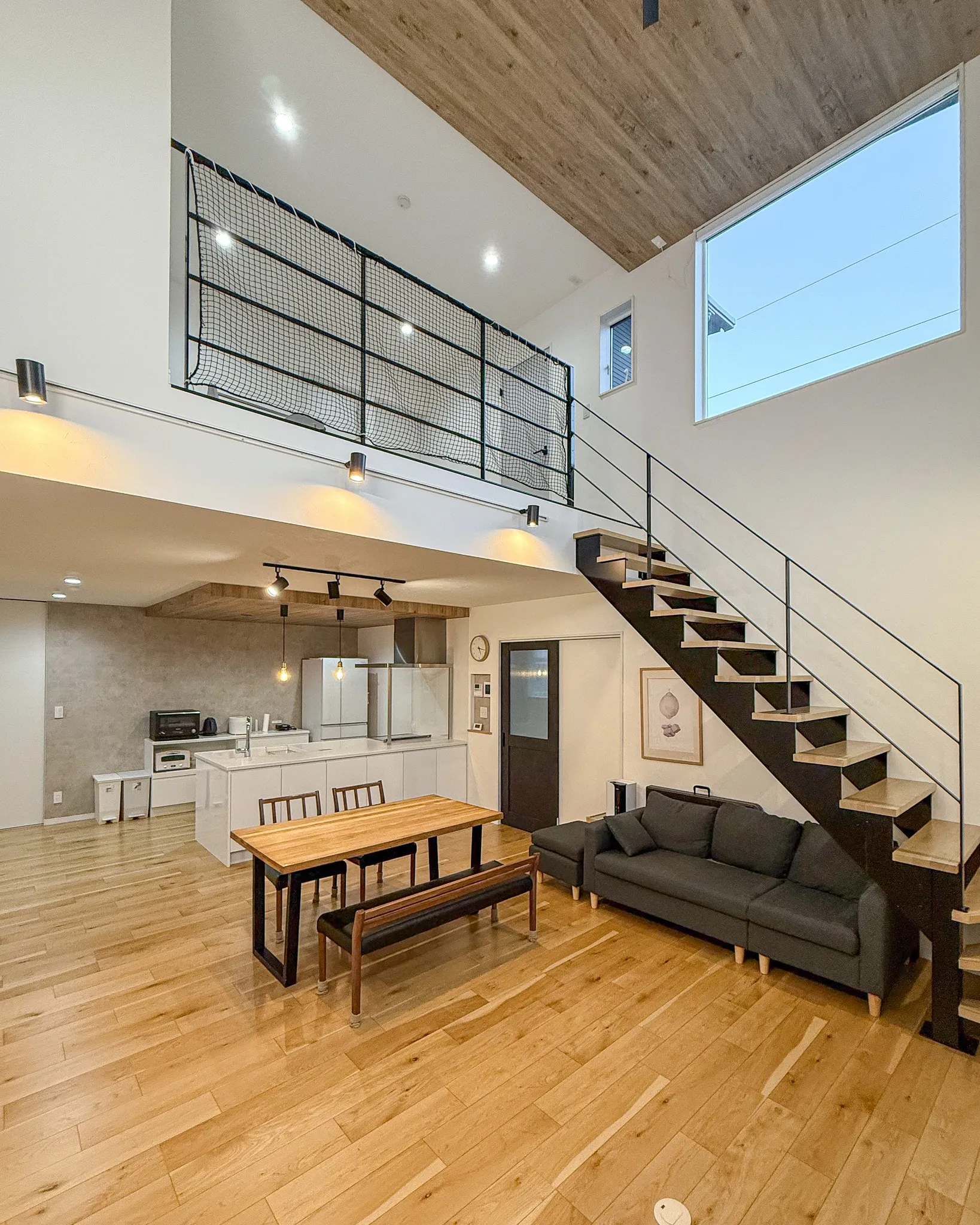 吹き抜けの高さがもたらす贅沢な開放感を感じられるリビングルー...