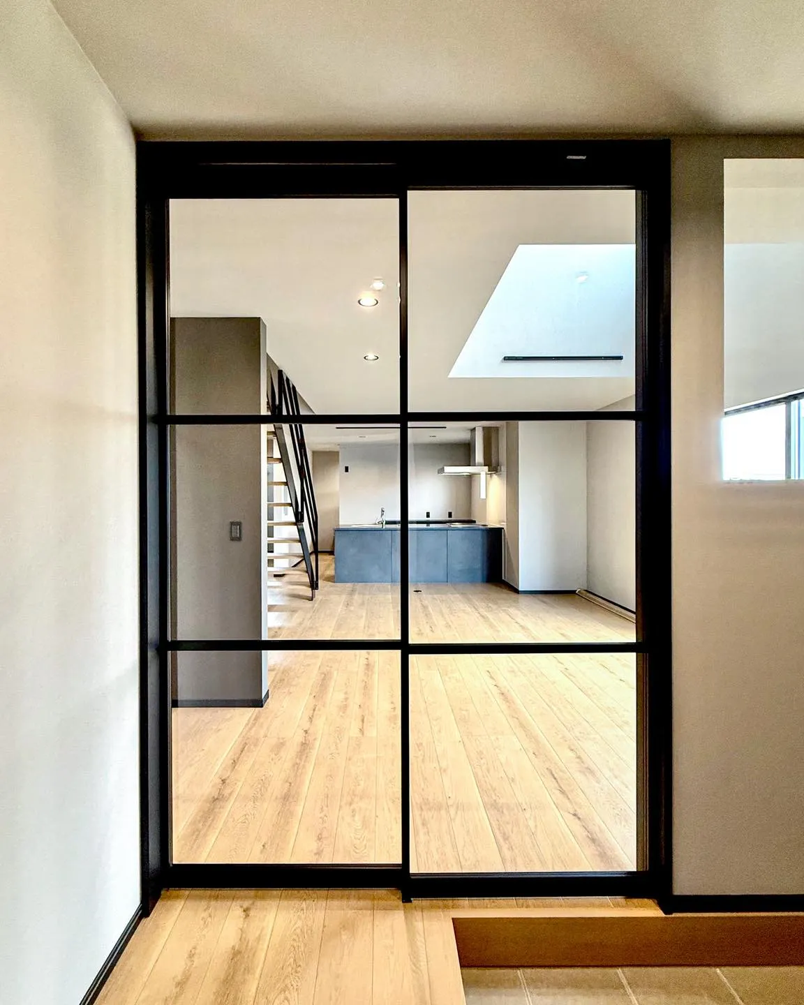 ガラス扉と吹き抜けが、空間に抜け感を。